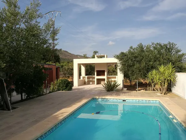 La piscina terminada, con barbacoa de obra al fondo
